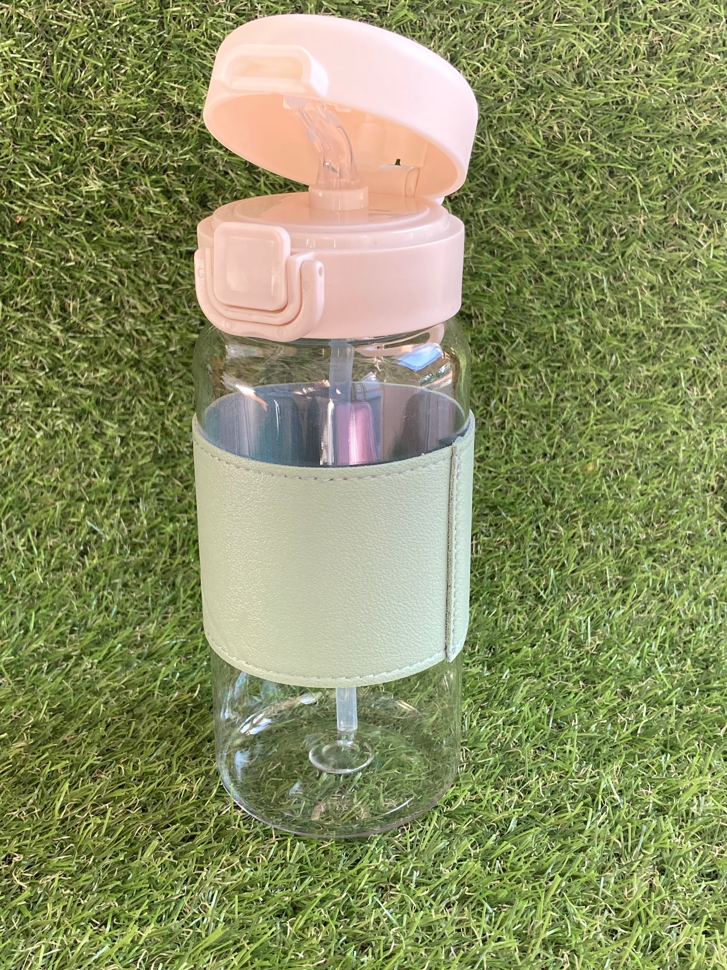 Clear plastic bottle with green sleeve and soccer ball key chain.