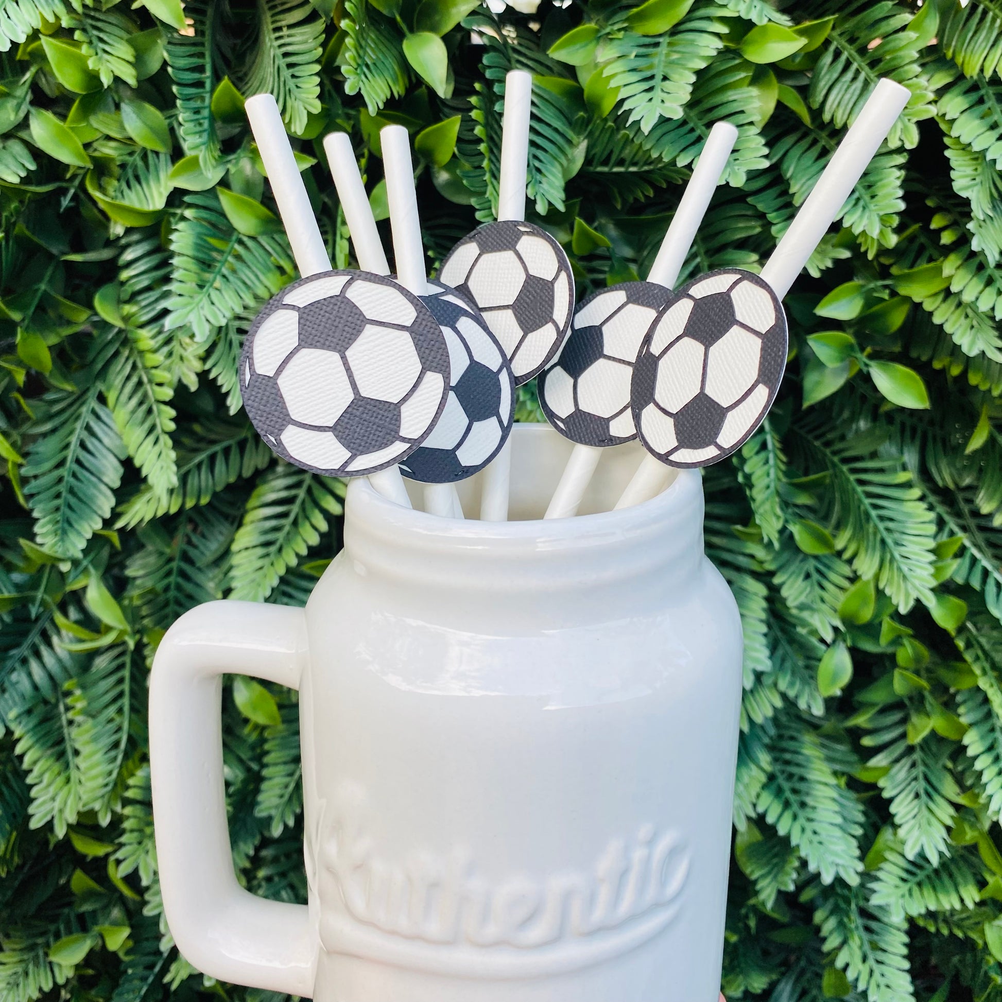 White Mason Jar with white straws topped with soccer ball paper straw toppers.