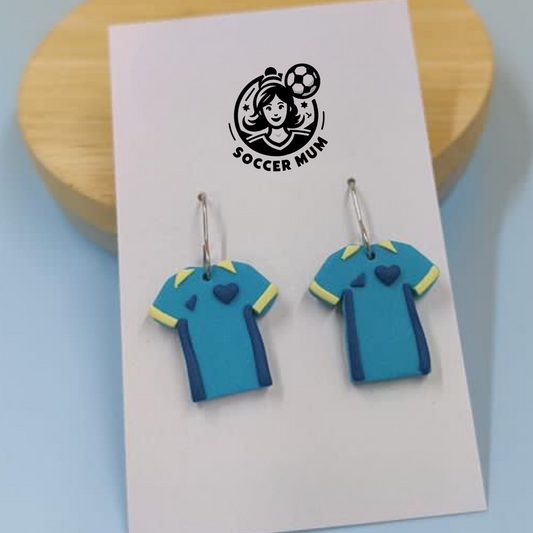 Matilda teal and yellow soccer kit shirts on a earring board with Soccer Mum Brand logo.