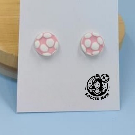 Pink and white soccer ball stud earrings on a earring board with Soccer Mum brand logo. 
