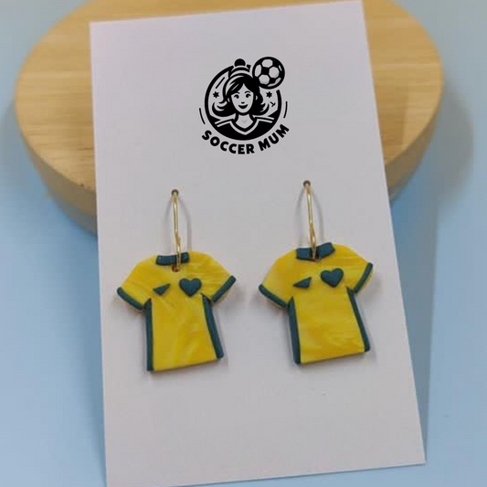Yellow and green Socceroo Australian Shirt kits as dangle earrings on a earring board with Soccer Mum brand logo.
